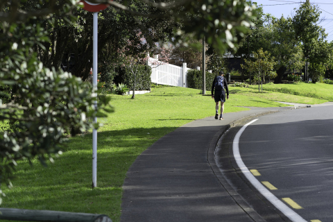 Man walking on residential street wearning back pack