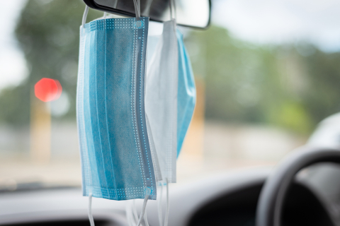 Face masks hanging from car rear view mirror